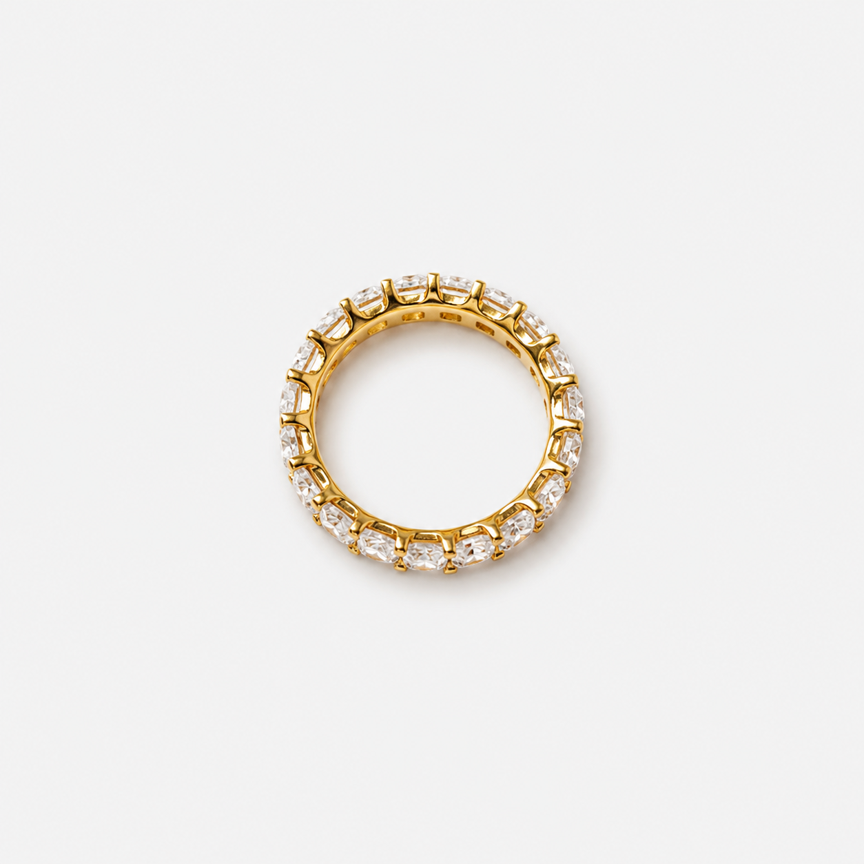 Gold ring with embedded diamonds on a light gray background