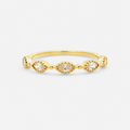 Gold ring with three small diamonds on a light gray background