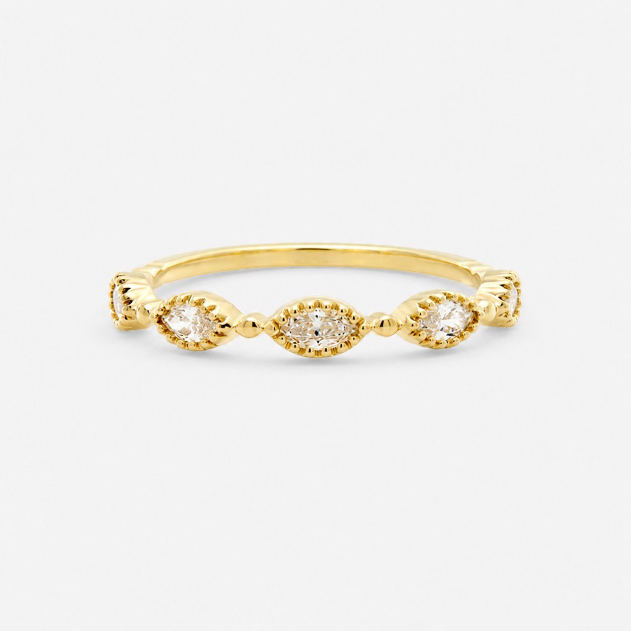Gold ring with three small diamonds on a light gray background
