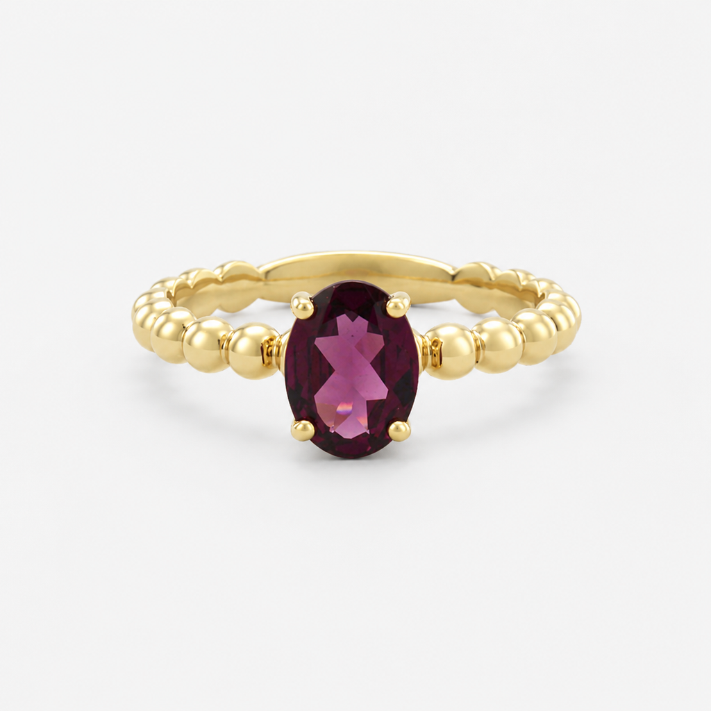 Gold ring with a purple gemstone on a white background