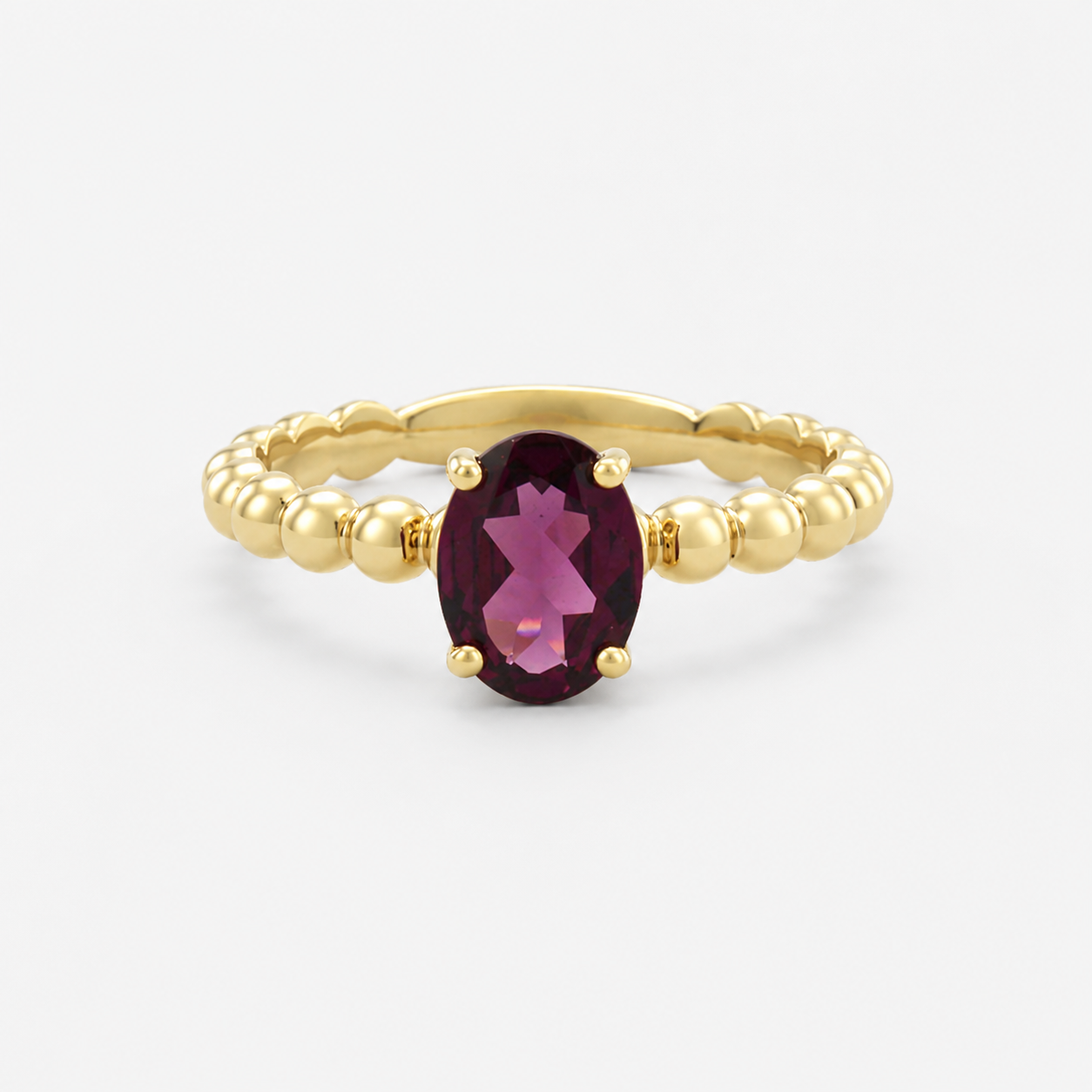 Gold ring with a purple gemstone on a white background