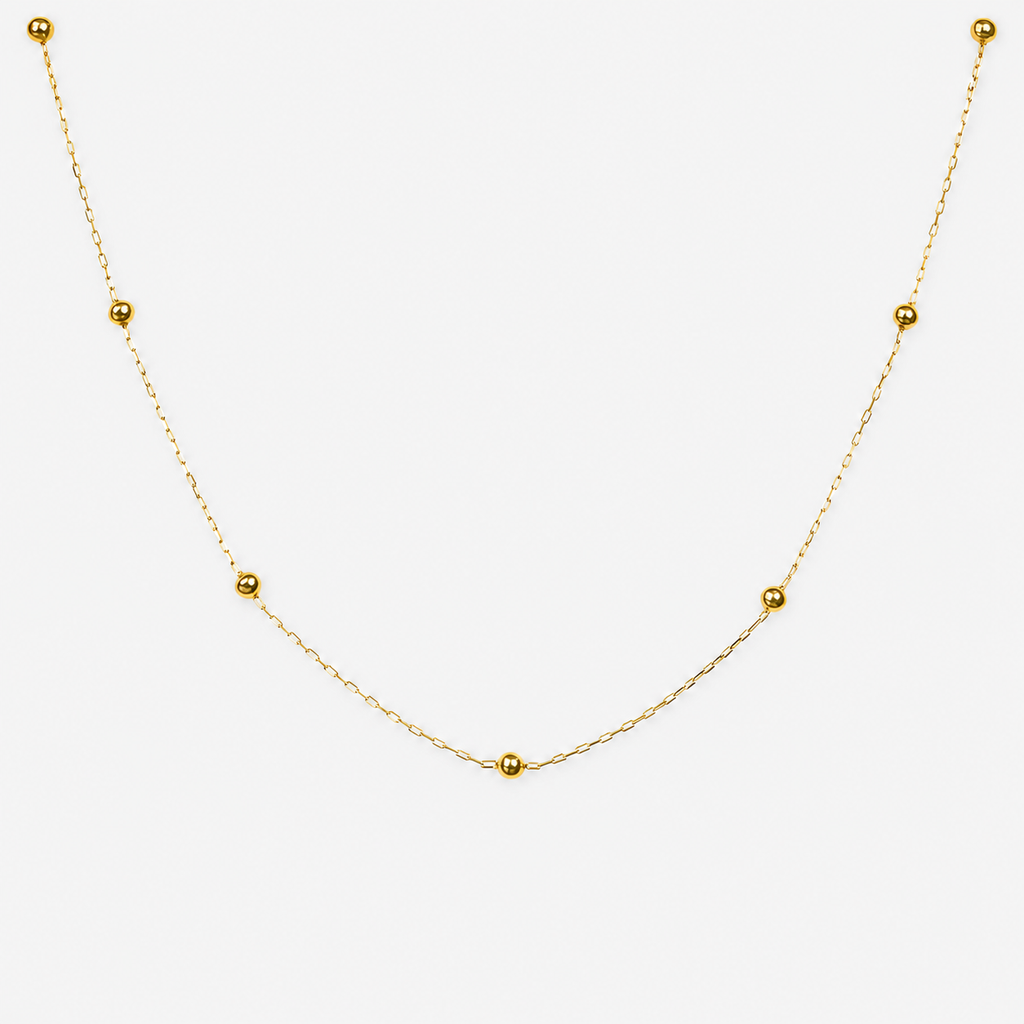 Gold necklace with small beads on a white background
