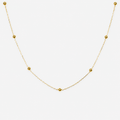Gold necklace with small beads on a white background