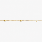 Gold bracelet with small beads on a white background