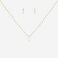 Gold necklace and earrings with pearl drops on a white background
