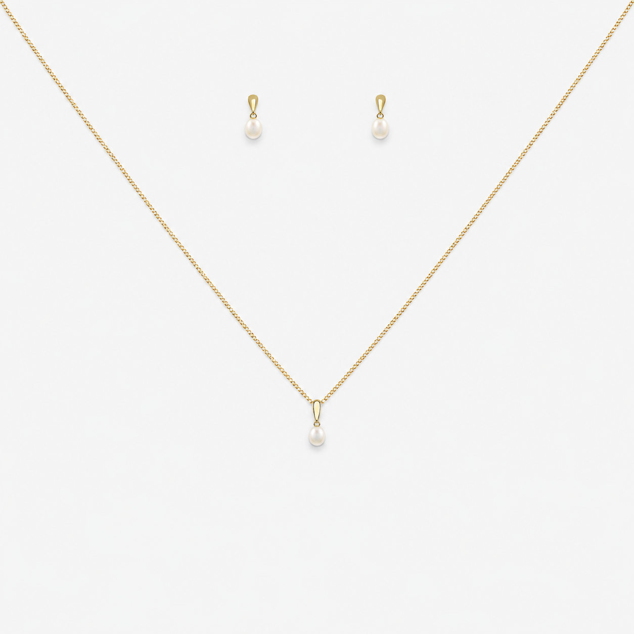 Gold necklace and earrings with pearl drops on a white background