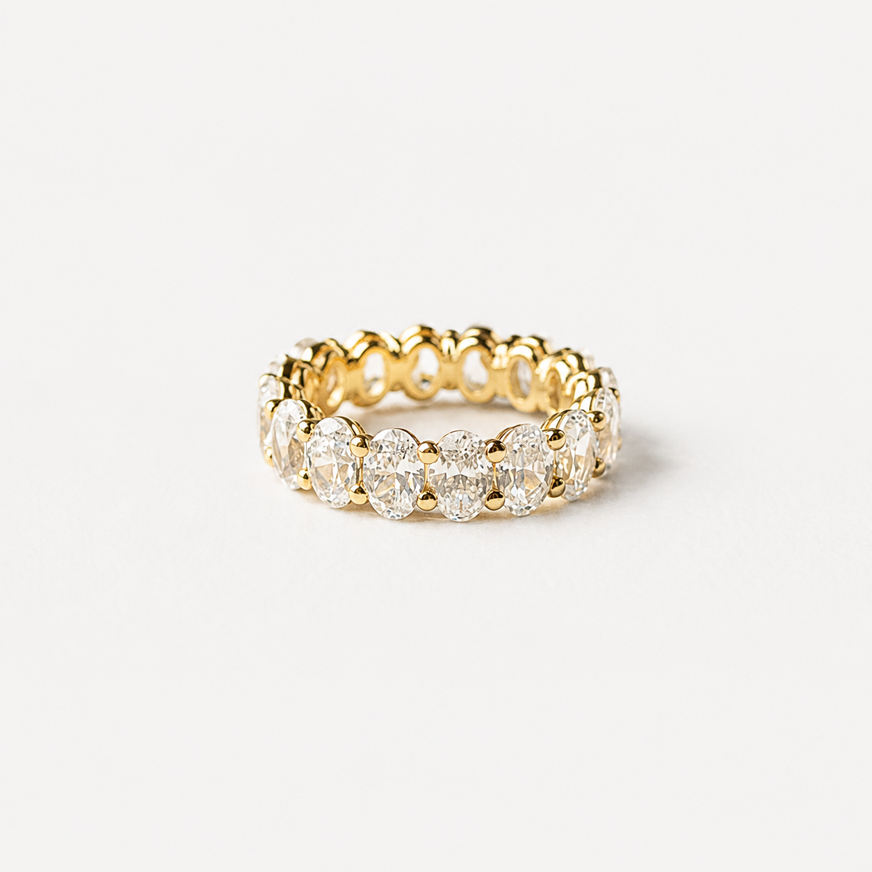 Gold ring with diamonds on a light gray background