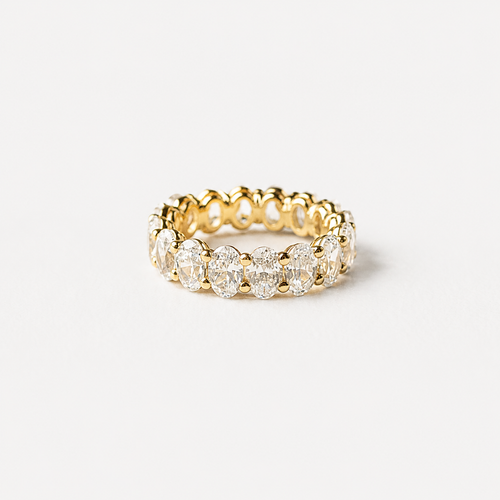 Gold ring with diamonds on a light gray background