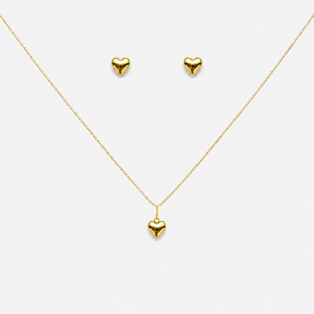 Gold heart necklace and earrings on a white background