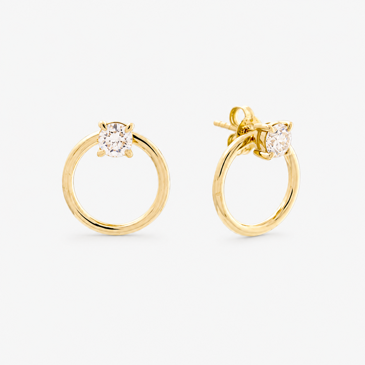 Gold hoop earrings with clear gemstones on a white background