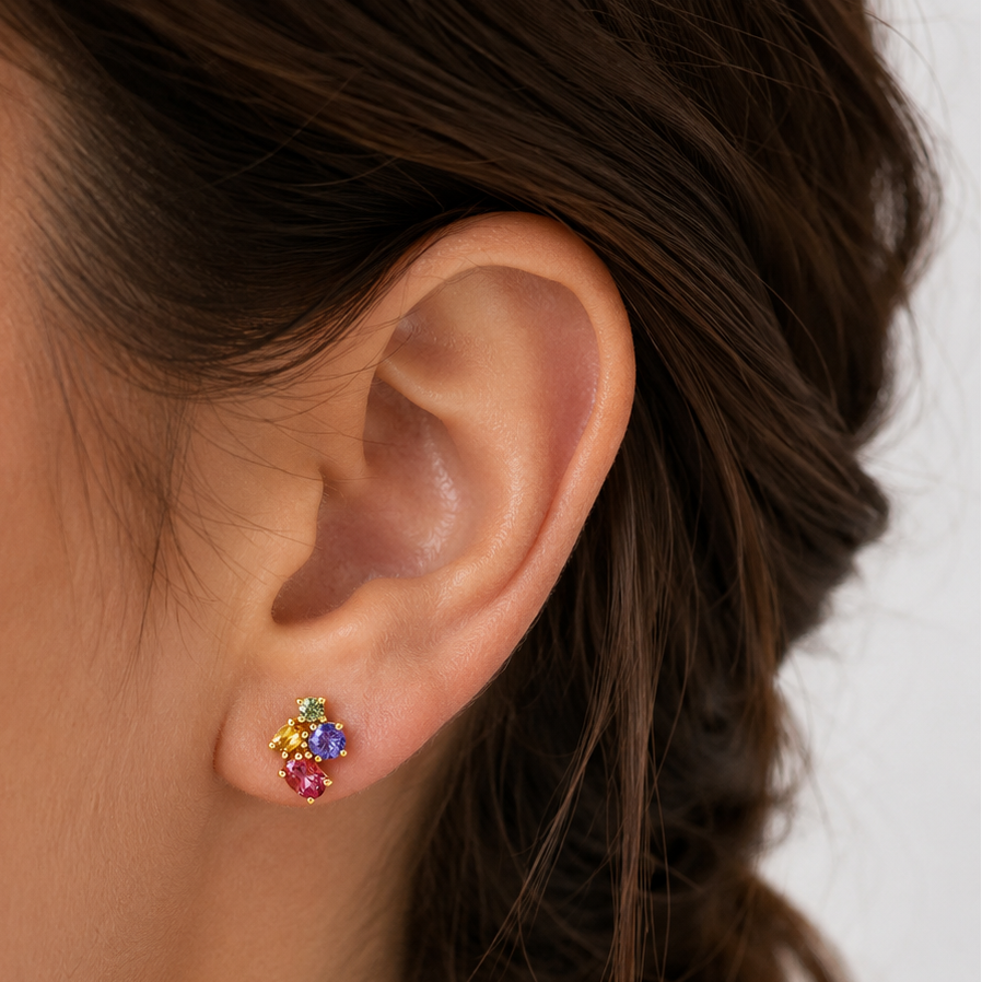Close-up of an ear wearing colorful floral earrings with a blurred background