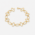 Gold chain bracelet on a light gray background