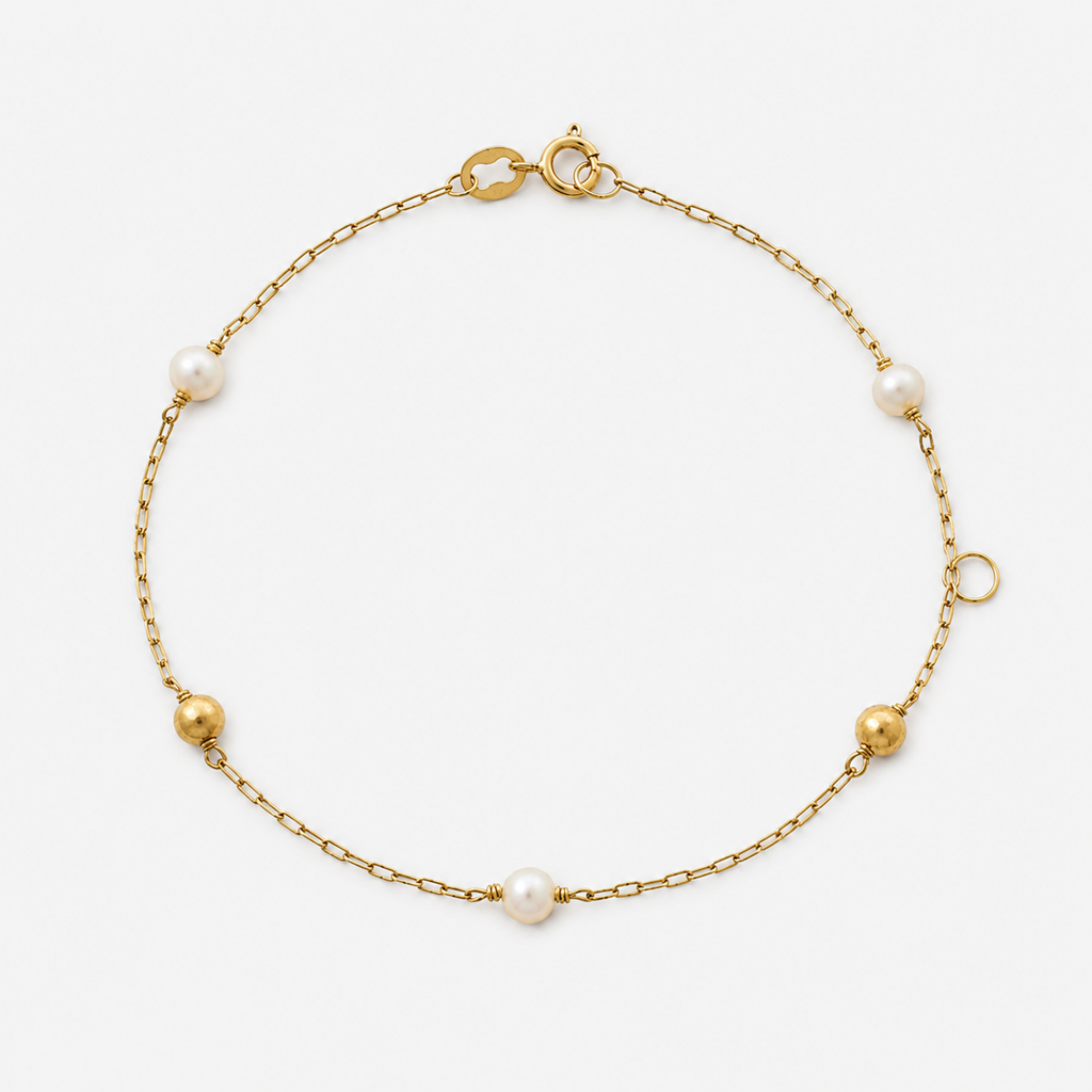 Gold bracelet with pearls on a white background