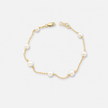 Gold bracelet with pearls on a white background