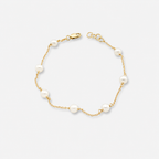 Gold bracelet with pearls on a white background