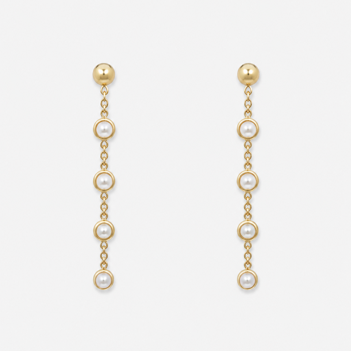 Gold chain earrings with pearl drops on a white background