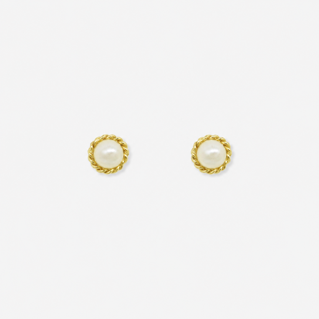 Pair of gold earrings with pearl centers on a white background