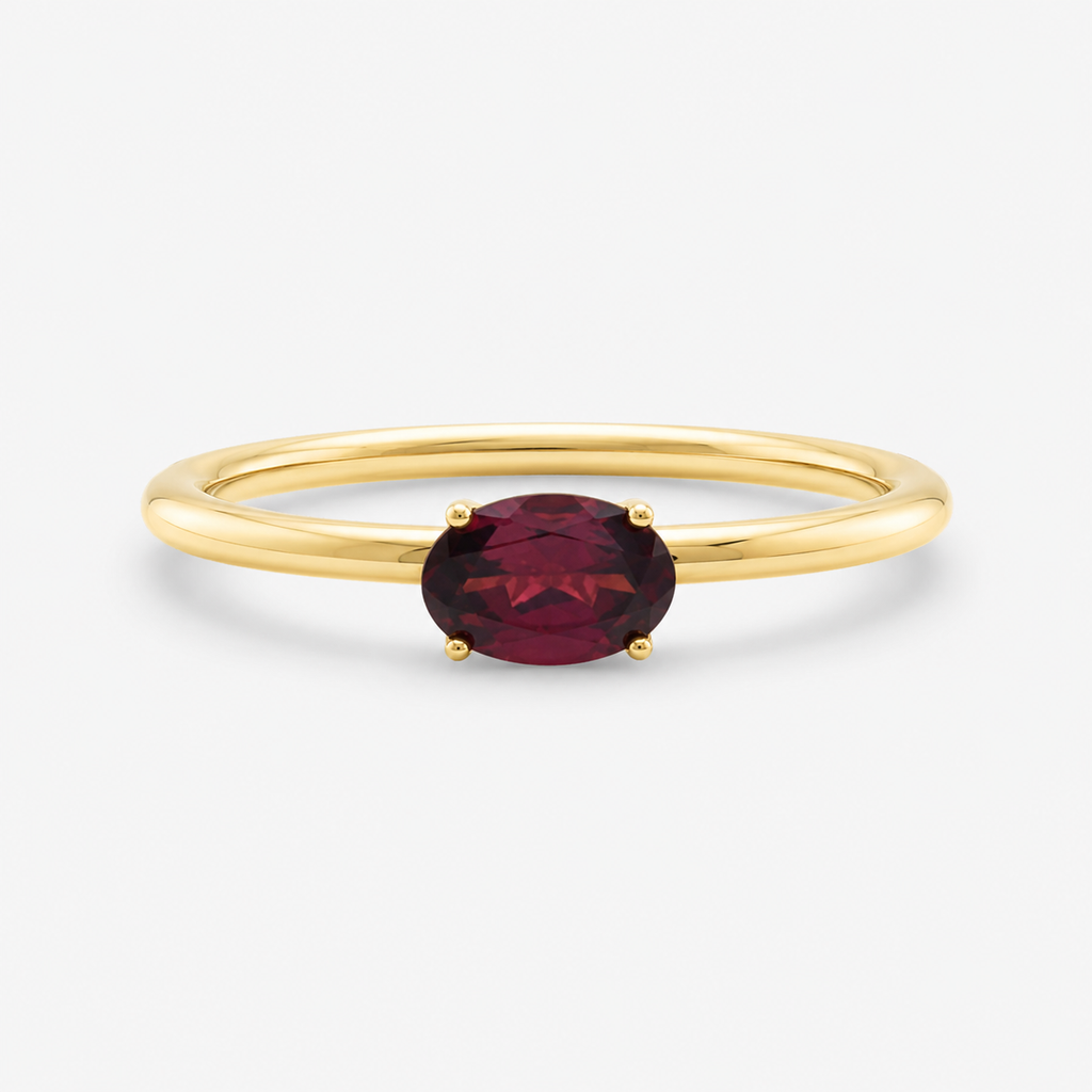 Gold ring with a red gemstone on a white background
