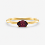 Gold ring with a red gemstone on a white background