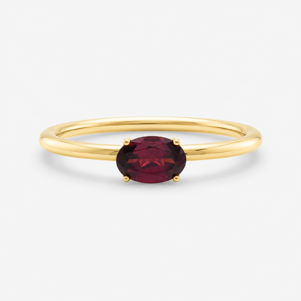 Gold ring with a red gemstone on a white background