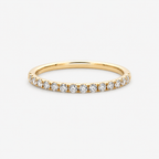 Gold ring with small diamonds on a light gray background