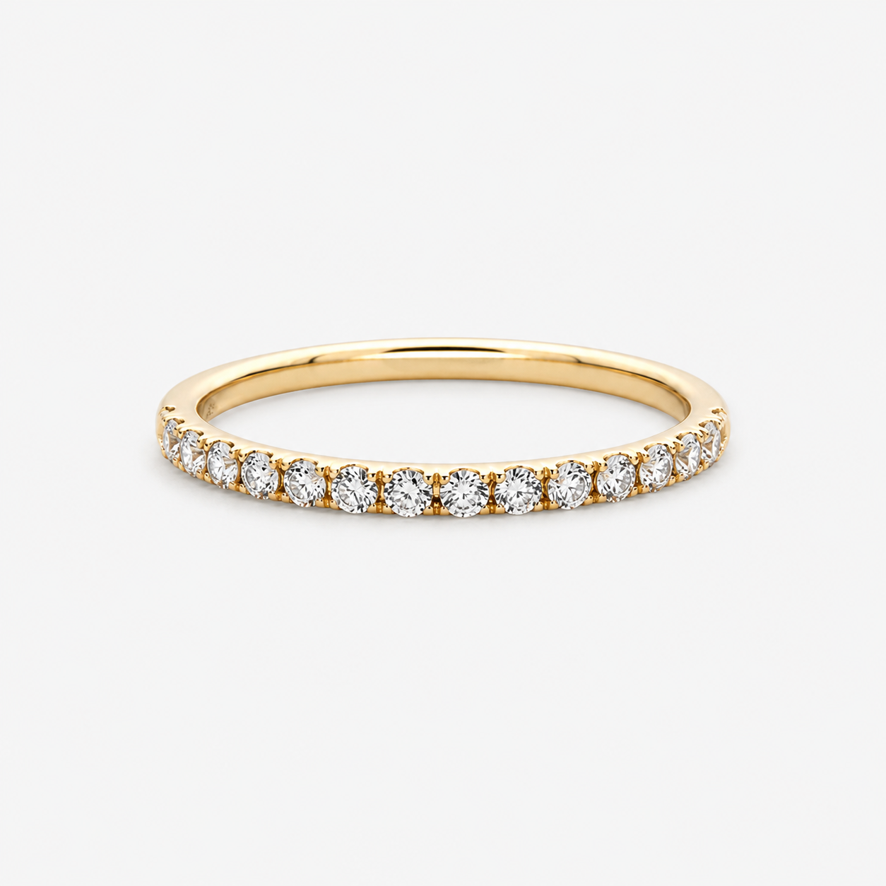 Gold ring with small diamonds on a light gray background
