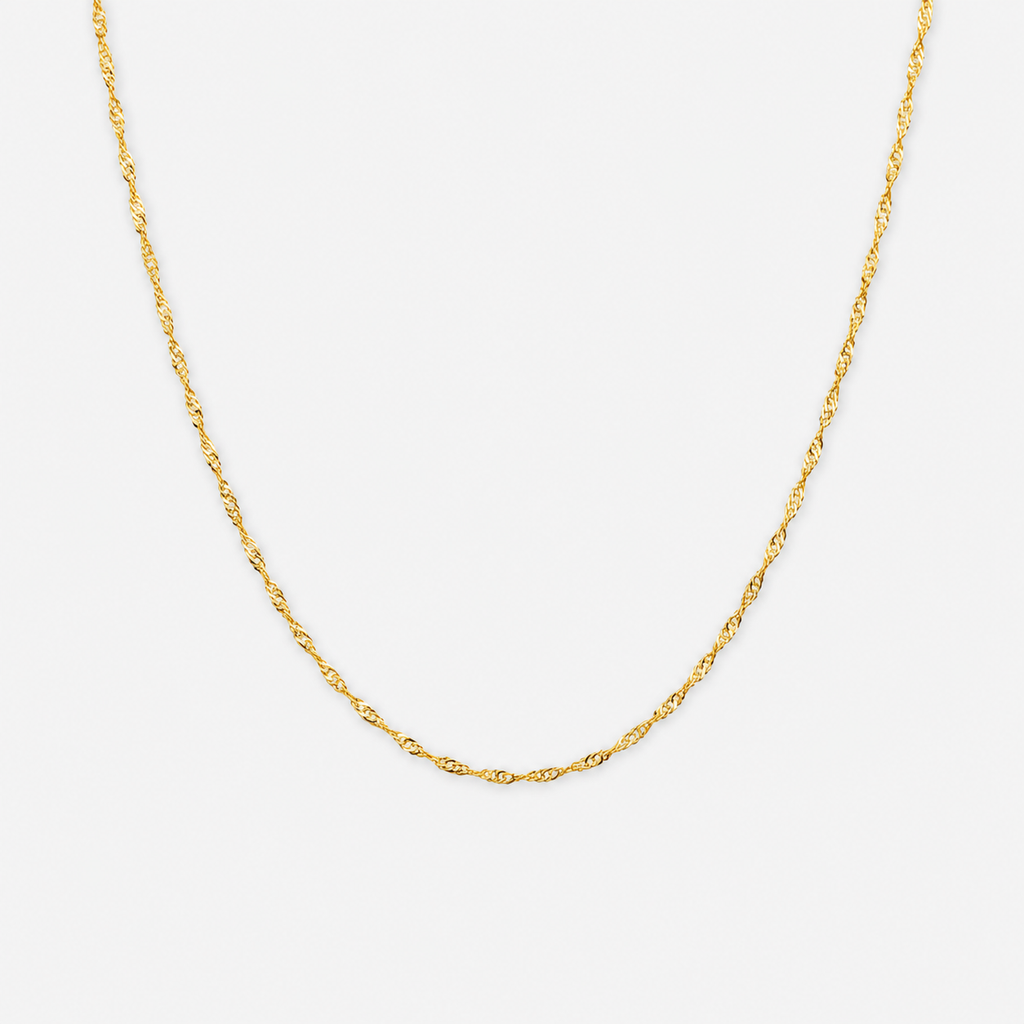 Gold chain necklace on a light gray background