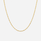 Gold chain necklace on a light gray background