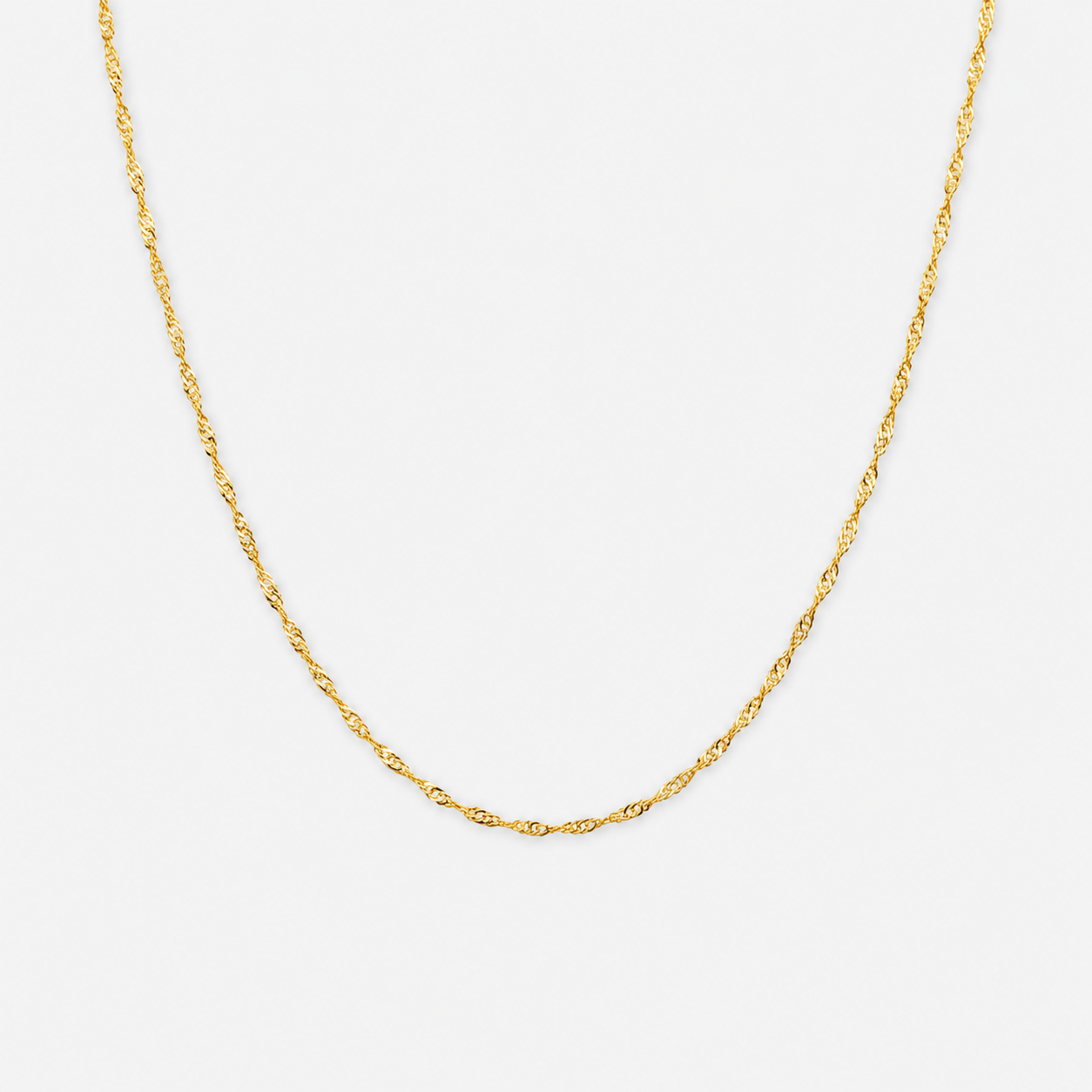 Gold chain necklace on a light gray background