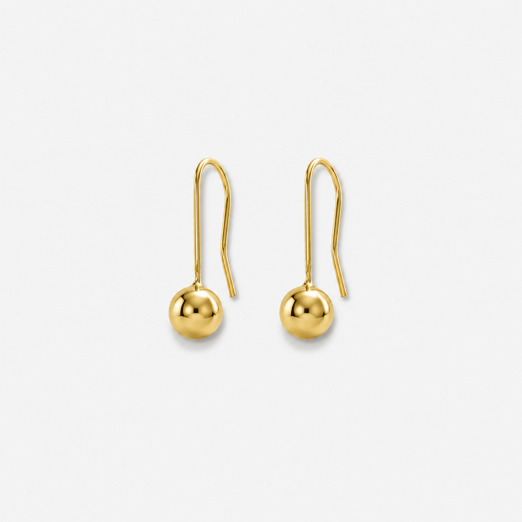 Gold earrings on a light gray background