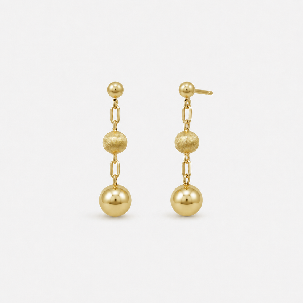 Pair of gold earrings with spherical beads on a white background