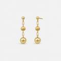 Pair of gold earrings with spherical beads on a white background